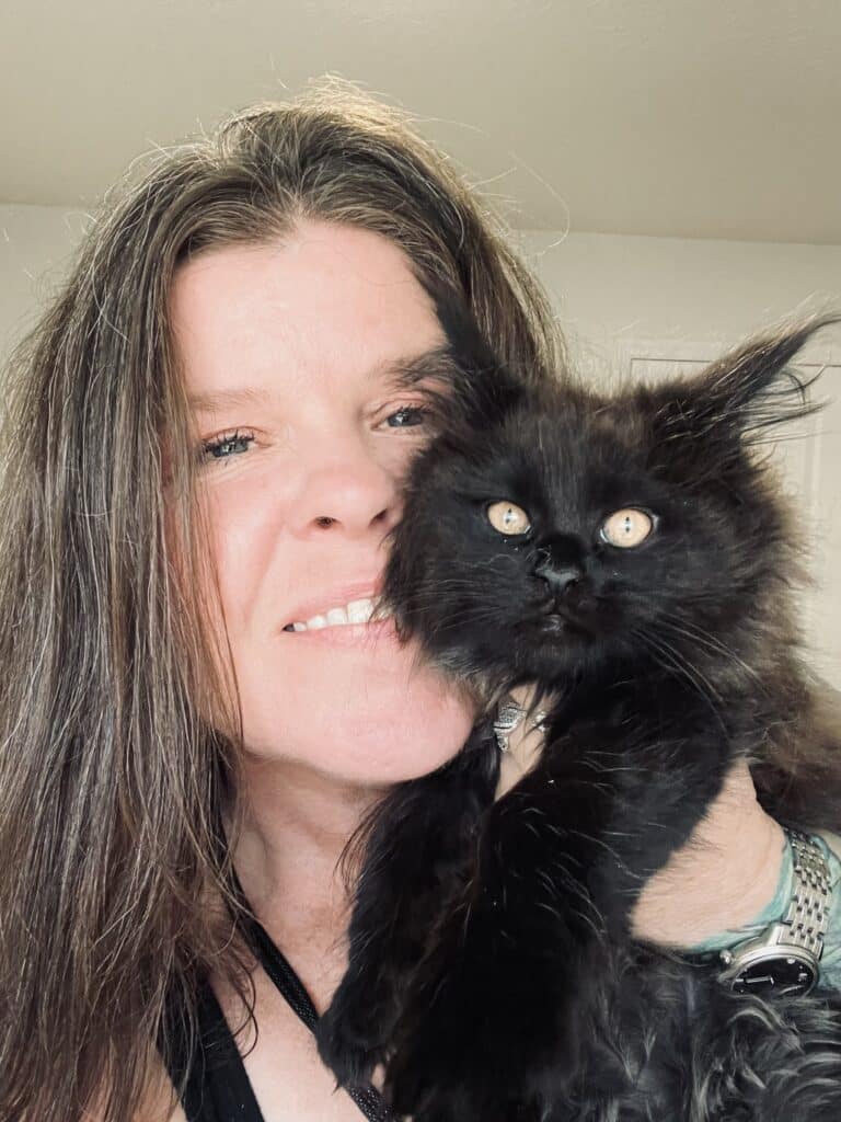 Tracy holding black maine coon kitten foe sale next to her face ⋆ Sassy Koonz Maine Coon Cattery black maine coon kitten produced by sassy Koonz